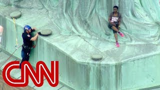 Protester climbs Statue of Liberty [upl. by Lilaj]